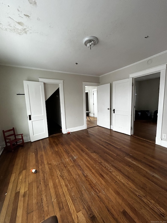 unfurnished bedroom featuring crown molding and dark hardwood / wood-style floors