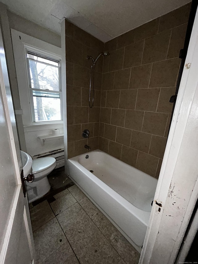 bathroom with tiled shower / bath, toilet, baseboard heating, and tile patterned floors