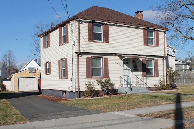 colonial inspired home with a wall unit AC, an outbuilding, and a garage