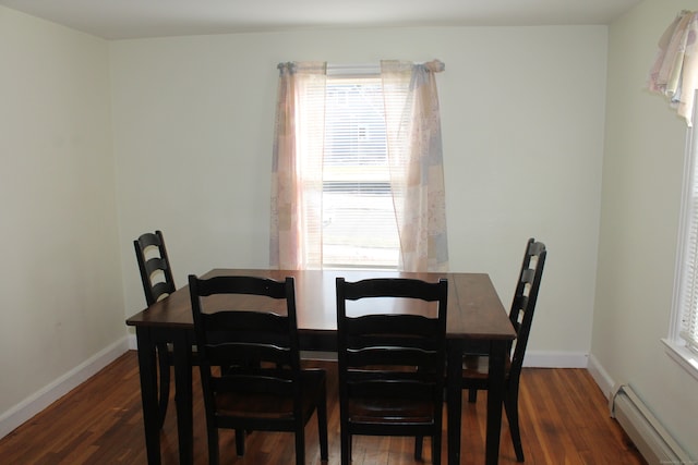 dining room featuring dark wood-type flooring and a baseboard heating unit