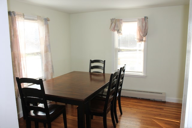 dining room with a wealth of natural light, a baseboard radiator, and dark hardwood / wood-style floors