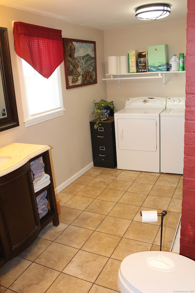 washroom with sink, light tile patterned floors, and washer and dryer