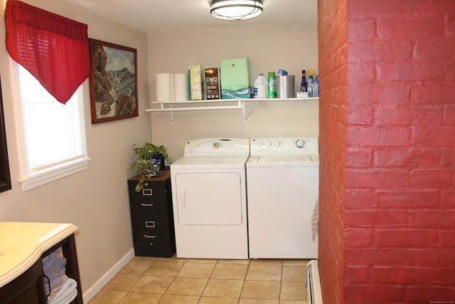 clothes washing area featuring light tile patterned floors, washing machine and dryer, and a baseboard heating unit