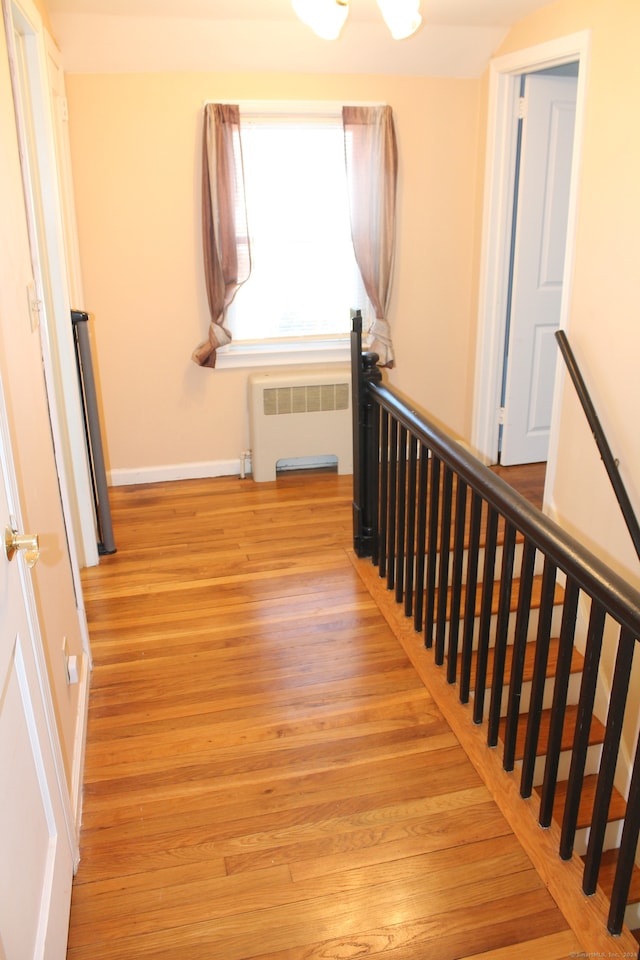 stairs with radiator heating unit and hardwood / wood-style floors