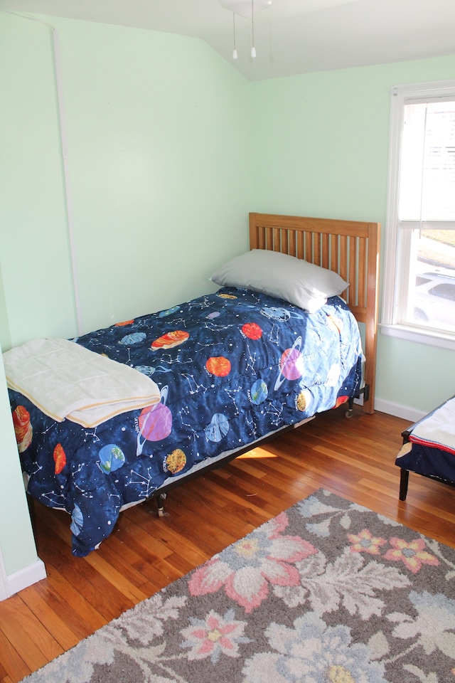 bedroom with vaulted ceiling and hardwood / wood-style flooring