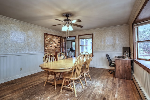 dining room with ceiling fan, crown molding, dark wood-type flooring, and a baseboard heating unit