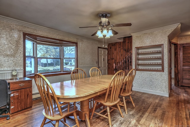 dining space with ceiling fan, dark wood-type flooring, a baseboard heating unit, and ornamental molding