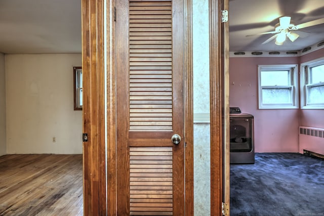 details featuring ceiling fan, radiator heating unit, wood-type flooring, and washer / dryer