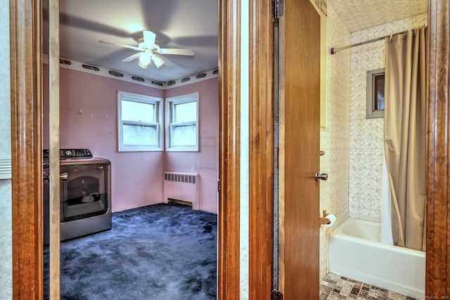 bathroom featuring ceiling fan, radiator heating unit, shower / bathtub combination with curtain, and washer / dryer