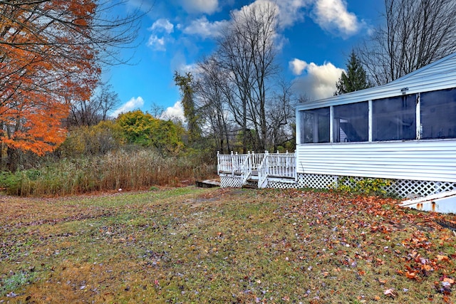 view of yard featuring a sunroom and a deck