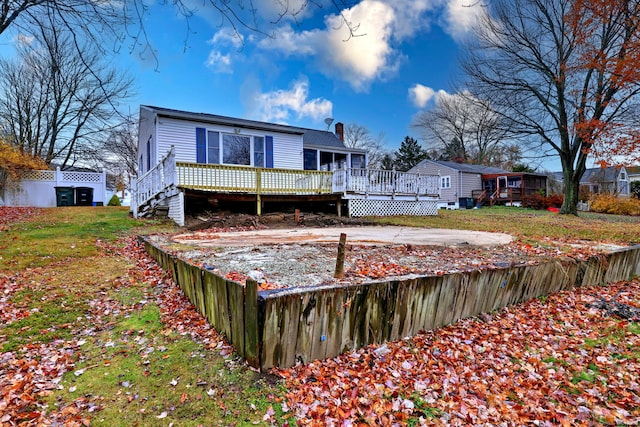 back of house with a deck and a yard