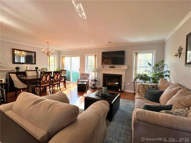 living room with hardwood / wood-style flooring, crown molding, and an inviting chandelier