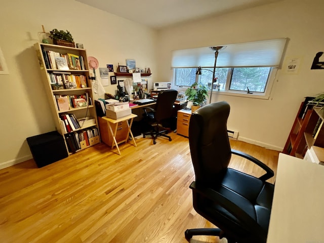 office with light wood-type flooring and a baseboard heating unit