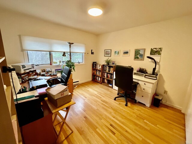 office with a baseboard heating unit and light wood-type flooring