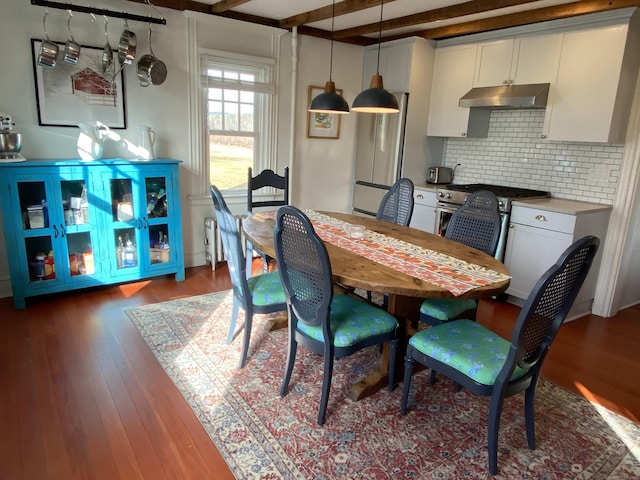 dining area with beamed ceiling and dark wood-type flooring