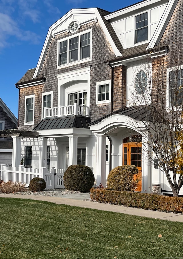 view of front of home featuring a balcony and a front yard