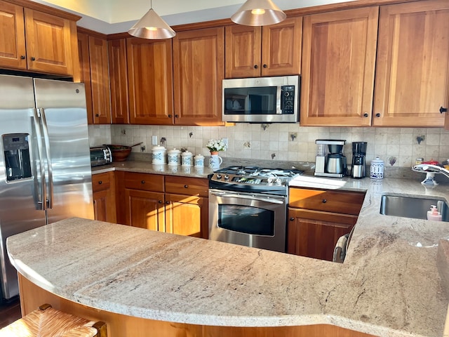 kitchen with a breakfast bar, sink, light stone countertops, appliances with stainless steel finishes, and tasteful backsplash