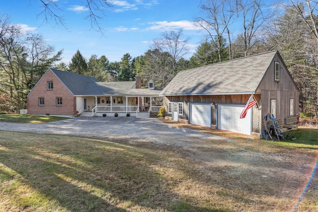 view of front of house featuring covered porch, a front yard, and a garage