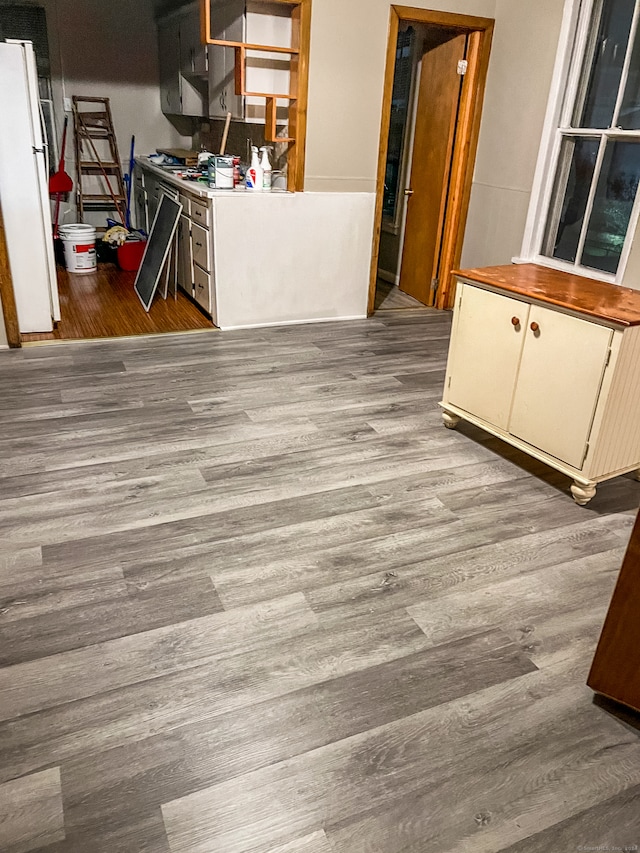 kitchen with white refrigerator, light hardwood / wood-style floors, and white cabinetry