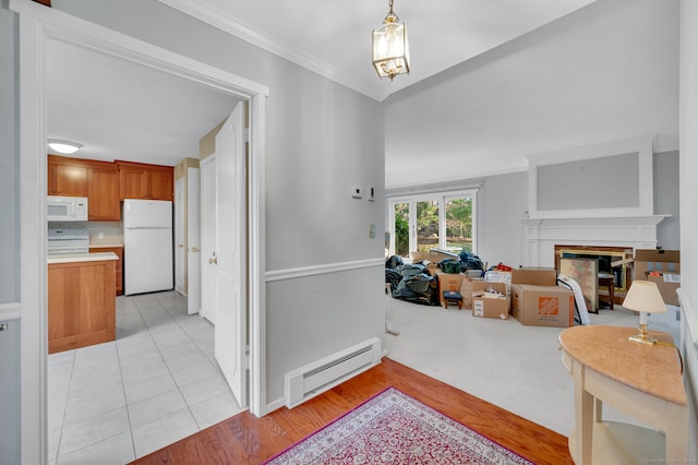 interior space with crown molding, light hardwood / wood-style flooring, and a baseboard heating unit