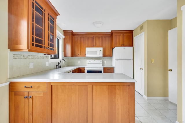 kitchen featuring sink, backsplash, kitchen peninsula, white appliances, and light tile patterned floors