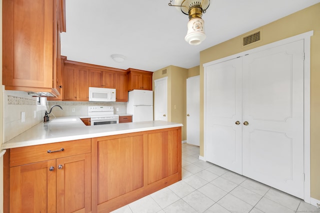 kitchen featuring light tile patterned floors, white appliances, backsplash, and sink