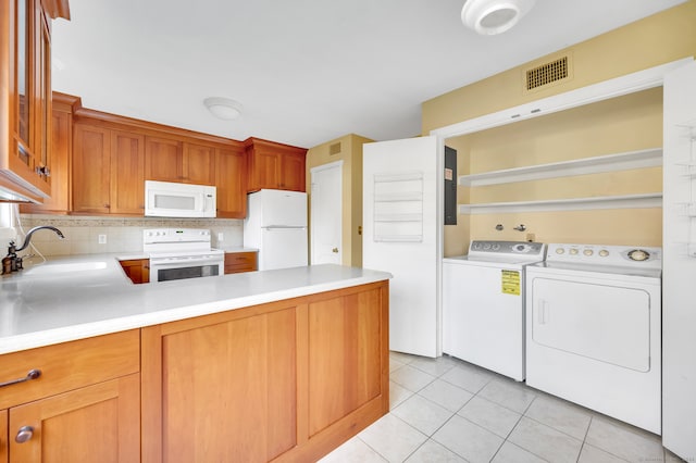 kitchen featuring sink, tasteful backsplash, white appliances, light tile patterned floors, and washer and dryer