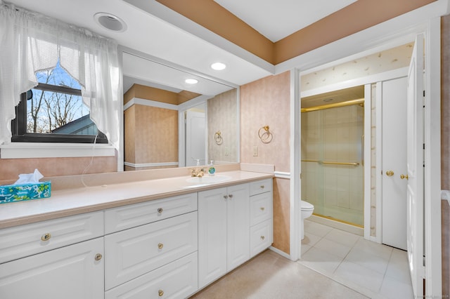 bathroom with tile patterned flooring, vanity, toilet, and walk in shower