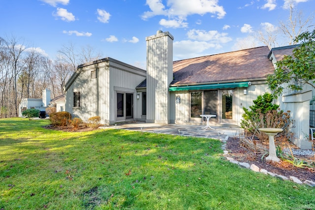 rear view of house with a patio area and a lawn