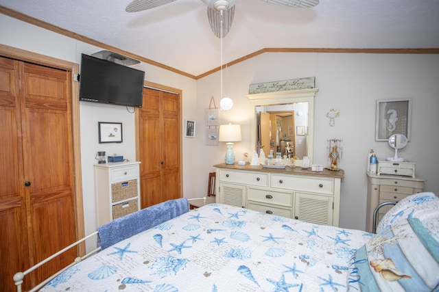 bedroom featuring multiple closets, crown molding, lofted ceiling, and ceiling fan