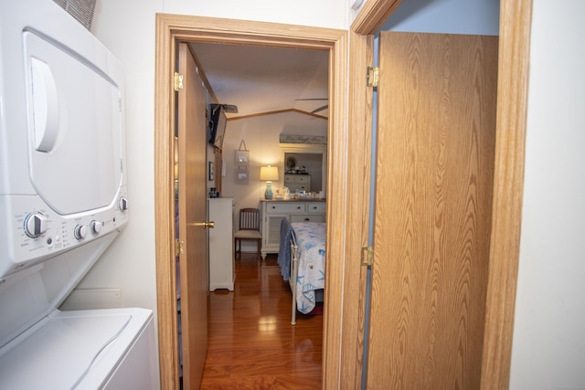 laundry room with stacked washer and clothes dryer and hardwood / wood-style floors