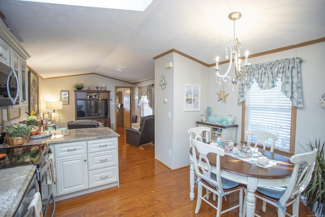 dining area with lofted ceiling, ornamental molding, light hardwood / wood-style floors, and a healthy amount of sunlight