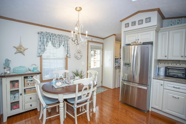 dining area with crown molding, a chandelier, and light wood-type flooring