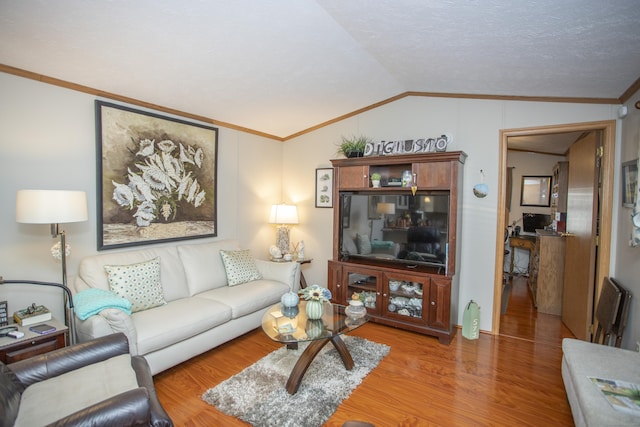 living room featuring crown molding, hardwood / wood-style flooring, and vaulted ceiling