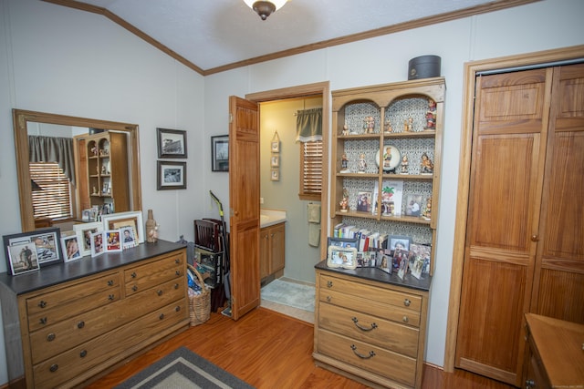 office space featuring ornamental molding, lofted ceiling, and light wood-type flooring