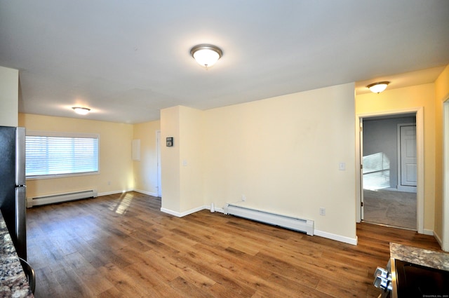 spare room with hardwood / wood-style floors and a baseboard radiator