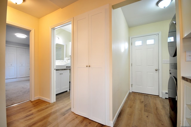 hall with light hardwood / wood-style floors and baseboard heating