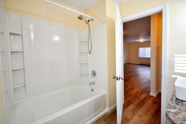 bathroom with vanity, hardwood / wood-style flooring, bathing tub / shower combination, and baseboard heating