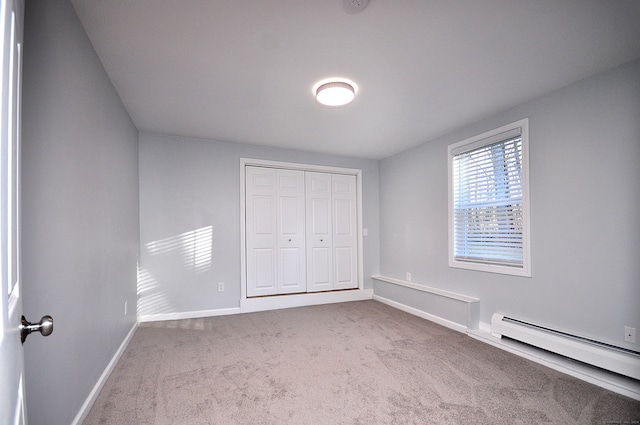 unfurnished bedroom featuring a closet, carpet floors, and a baseboard radiator