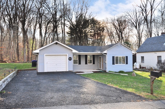 ranch-style home with a garage and a front lawn