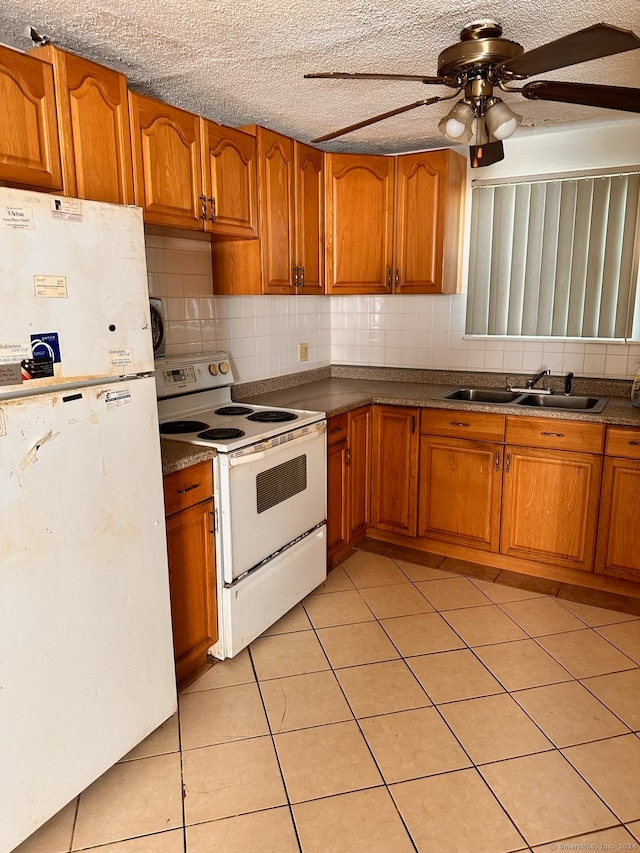 kitchen featuring white appliances, sink, a textured ceiling, tasteful backsplash, and light tile patterned flooring