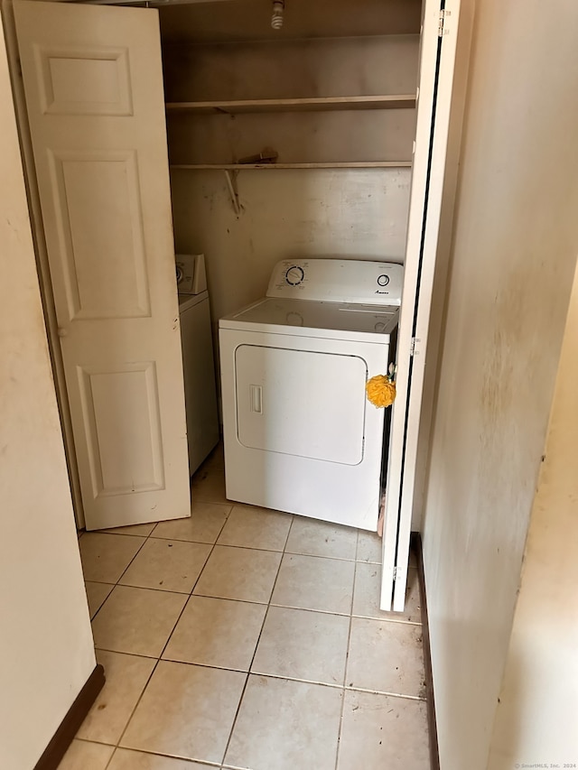 washroom with washing machine and dryer and light tile patterned floors