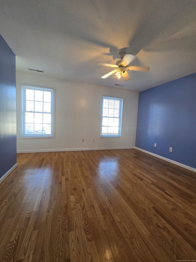 unfurnished room with ceiling fan, dark wood-type flooring, and a textured ceiling