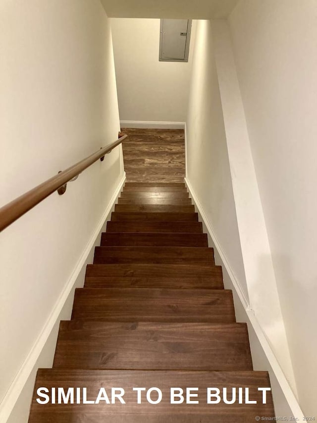 staircase with wood-type flooring and electric panel