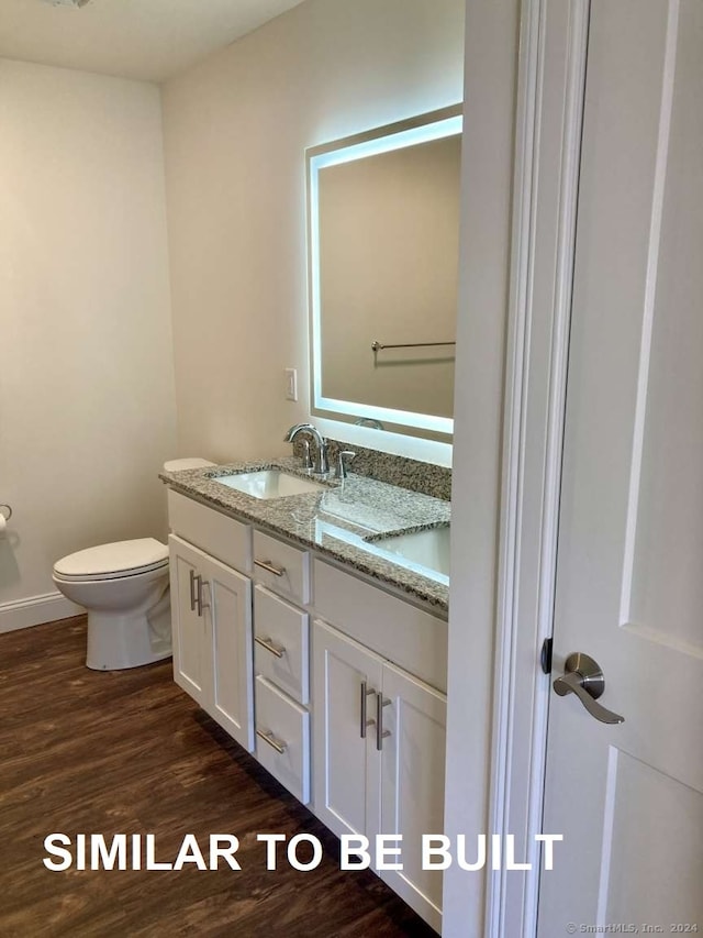 bathroom featuring hardwood / wood-style flooring, vanity, and toilet