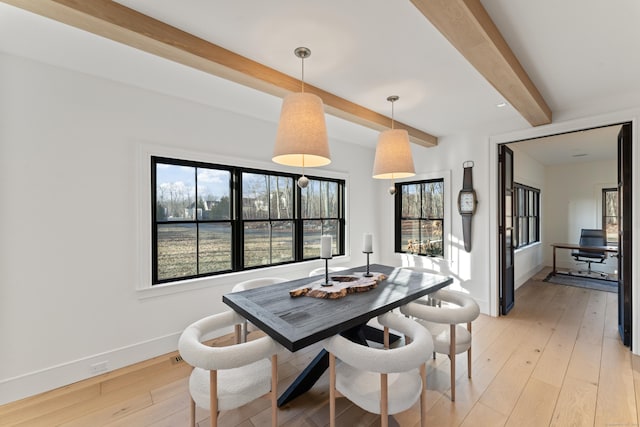 dining room featuring beam ceiling and light hardwood / wood-style floors