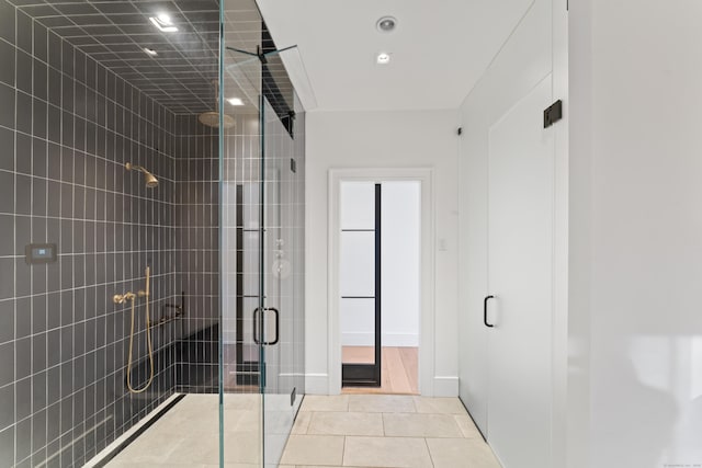 bathroom featuring tile patterned floors and a shower with door