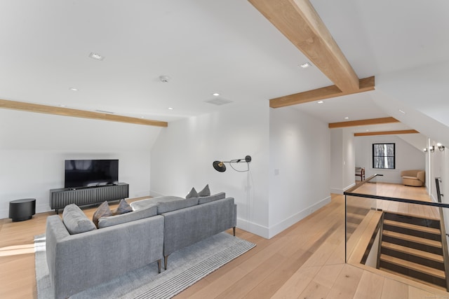 living room featuring lofted ceiling with beams and light hardwood / wood-style flooring