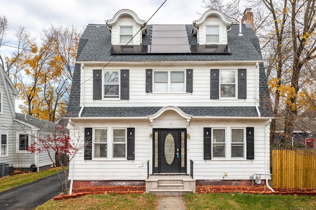 cape cod-style house with solar panels and central AC