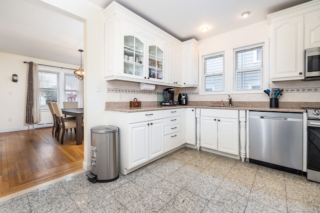 kitchen featuring sink, light hardwood / wood-style flooring, decorative light fixtures, white cabinetry, and stainless steel appliances